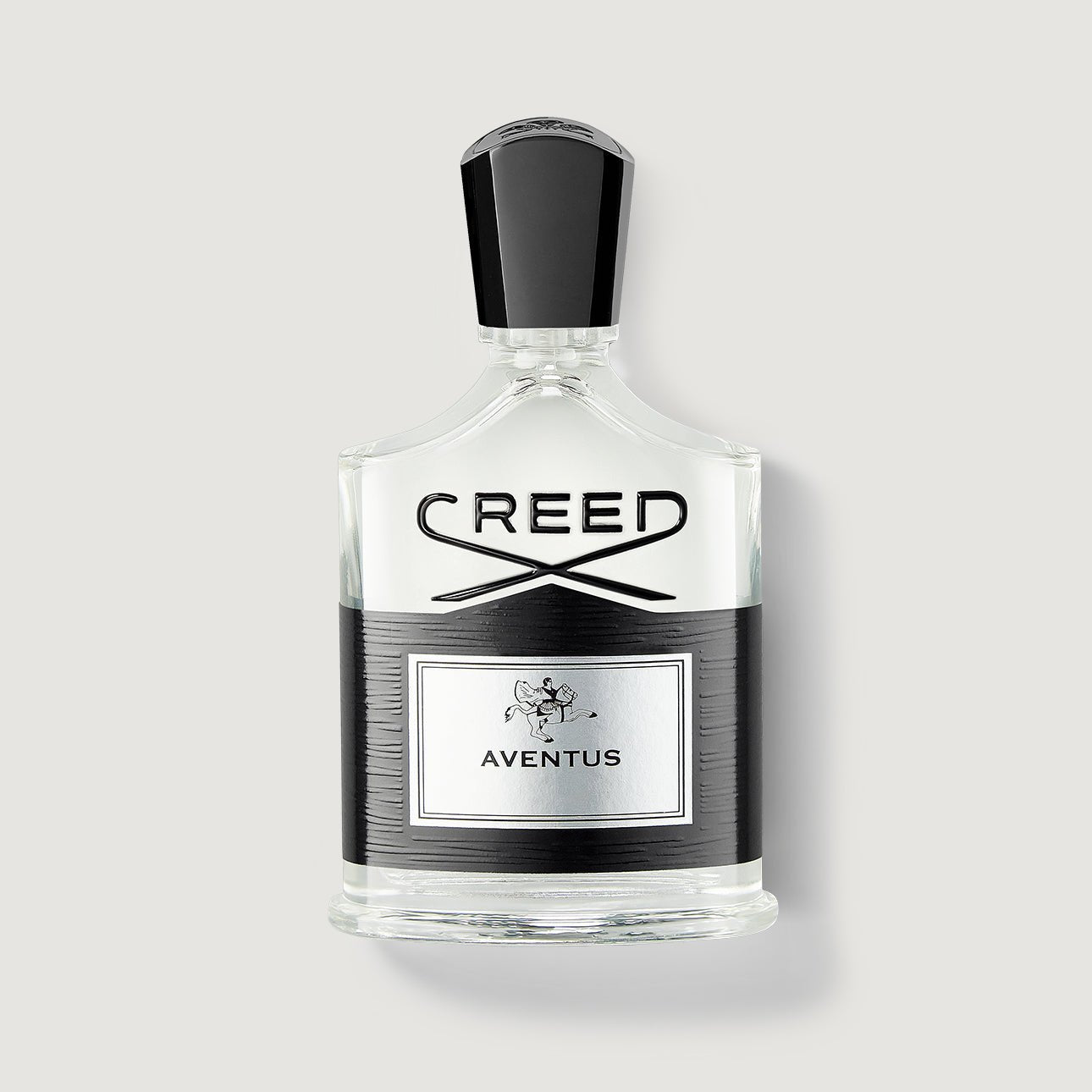 Creed Aventus bottle — clear squared glass with a black textured panel and silver plaque